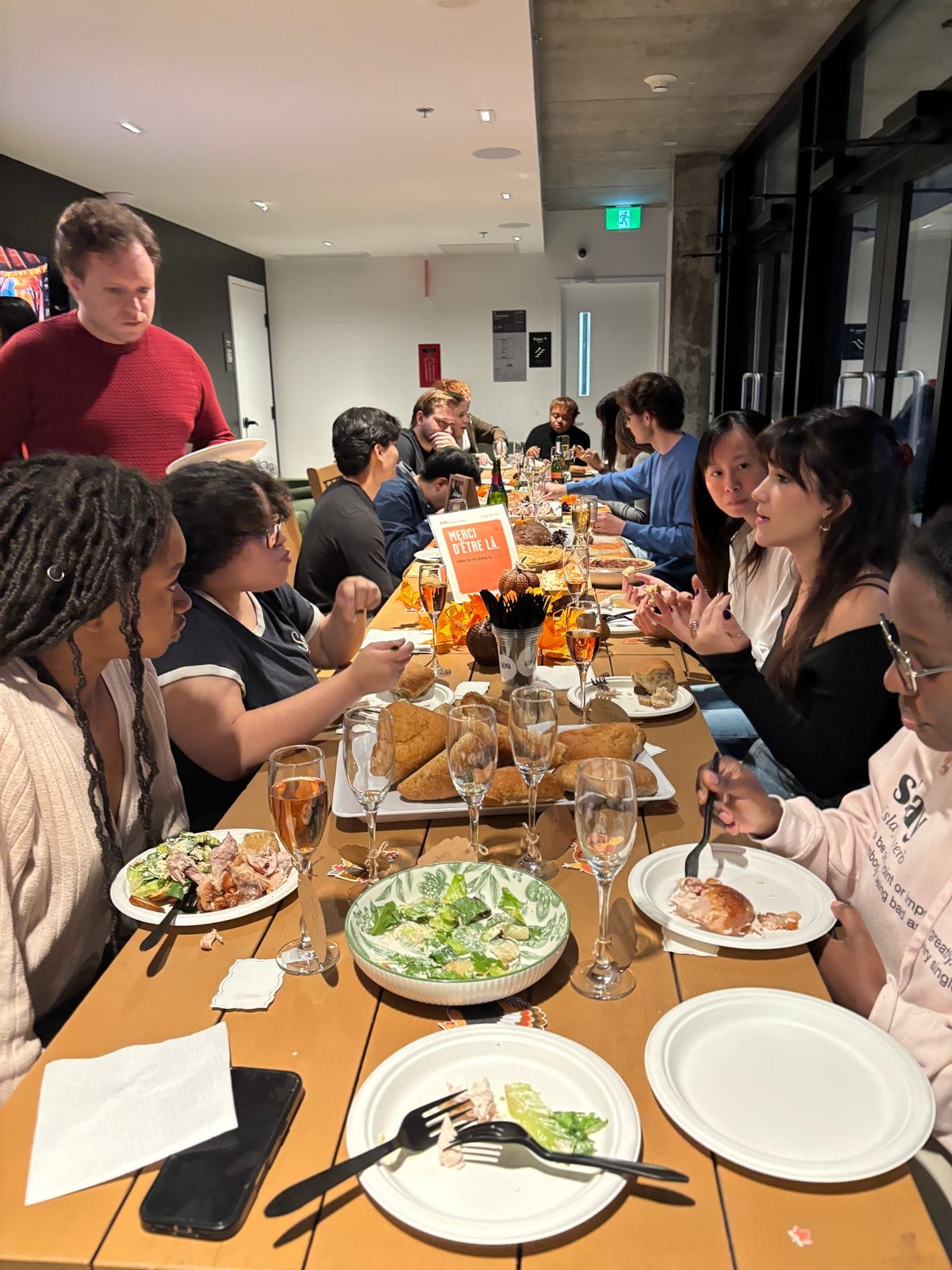 Residents around the Friendsgiving dinner table in the ALMA Shaughnessy Village lounge